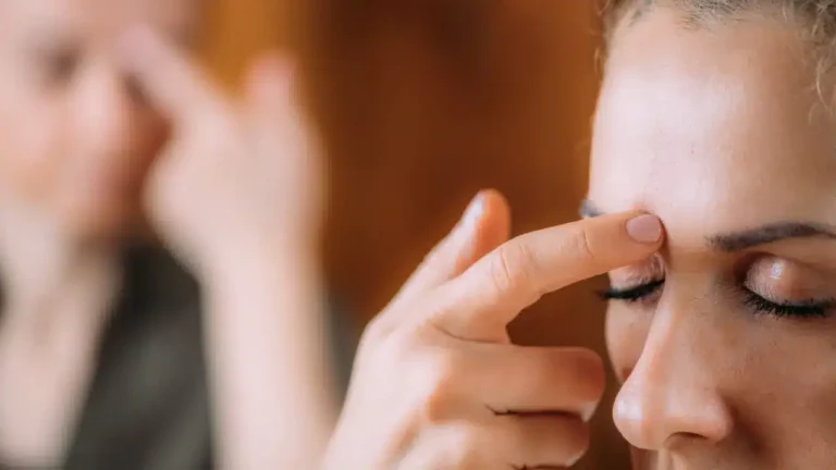 Woman practicing EFT tapping for anxiety by placing a finger on her forehead