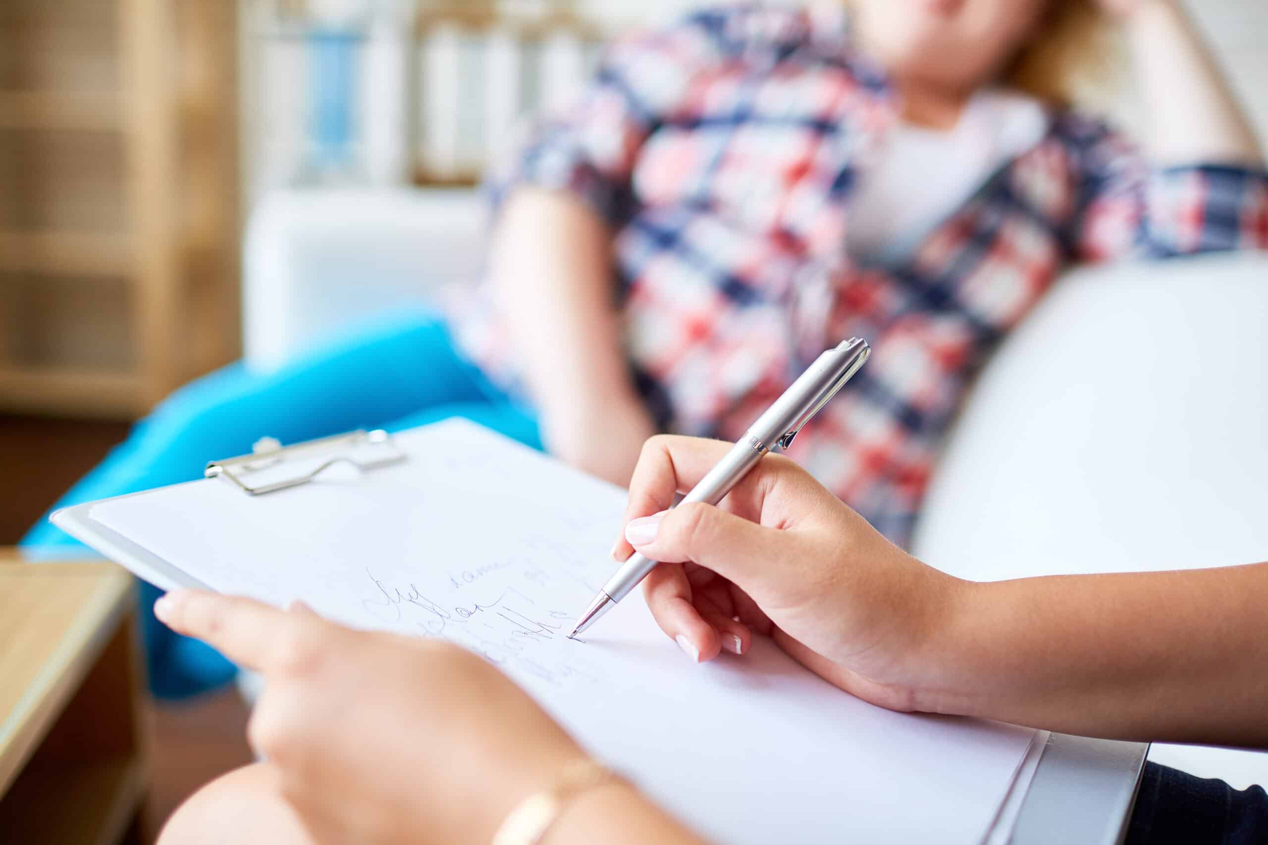 a therapist taking notes while giving psychotherapy to a patient at a residential treatment program