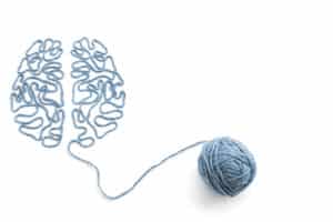 Ball of yarn and thread in the shape of the brain on a white background