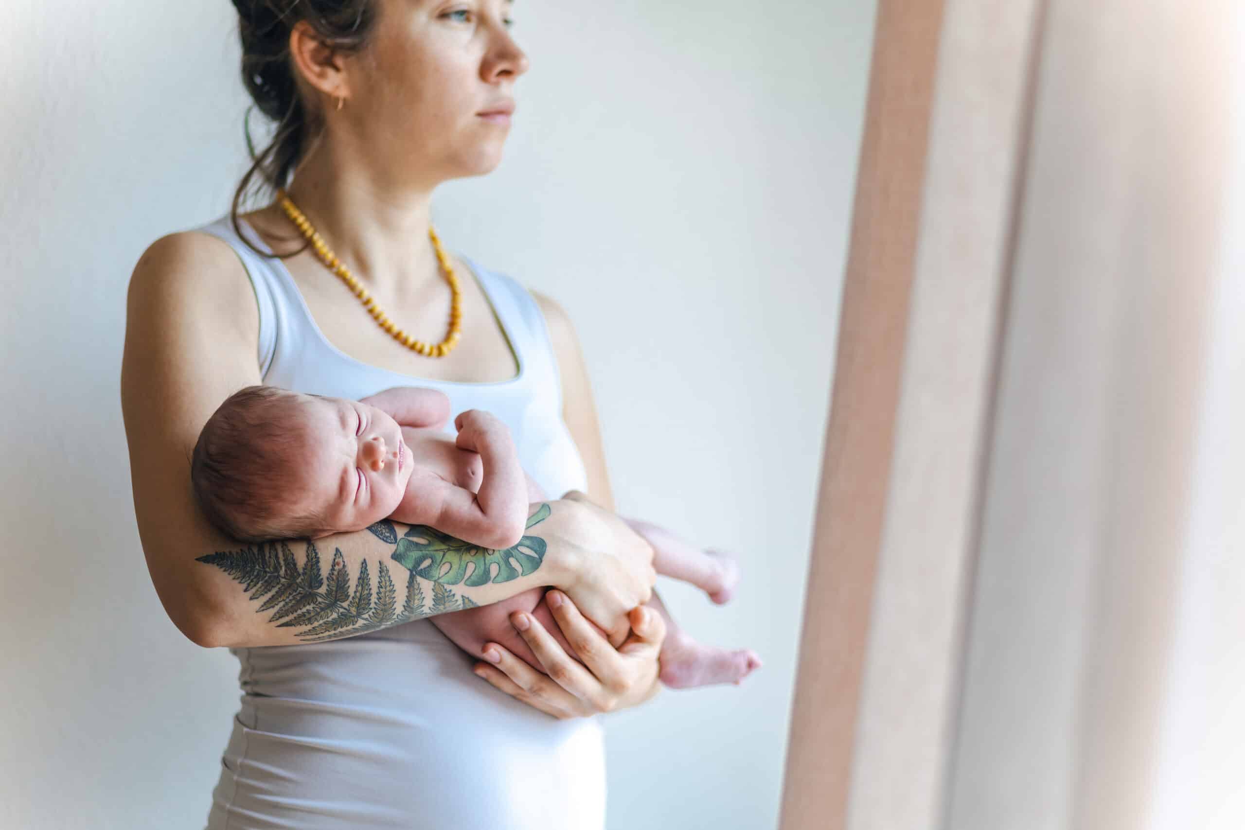 mom with newborn baby looking tired with postpartum depression