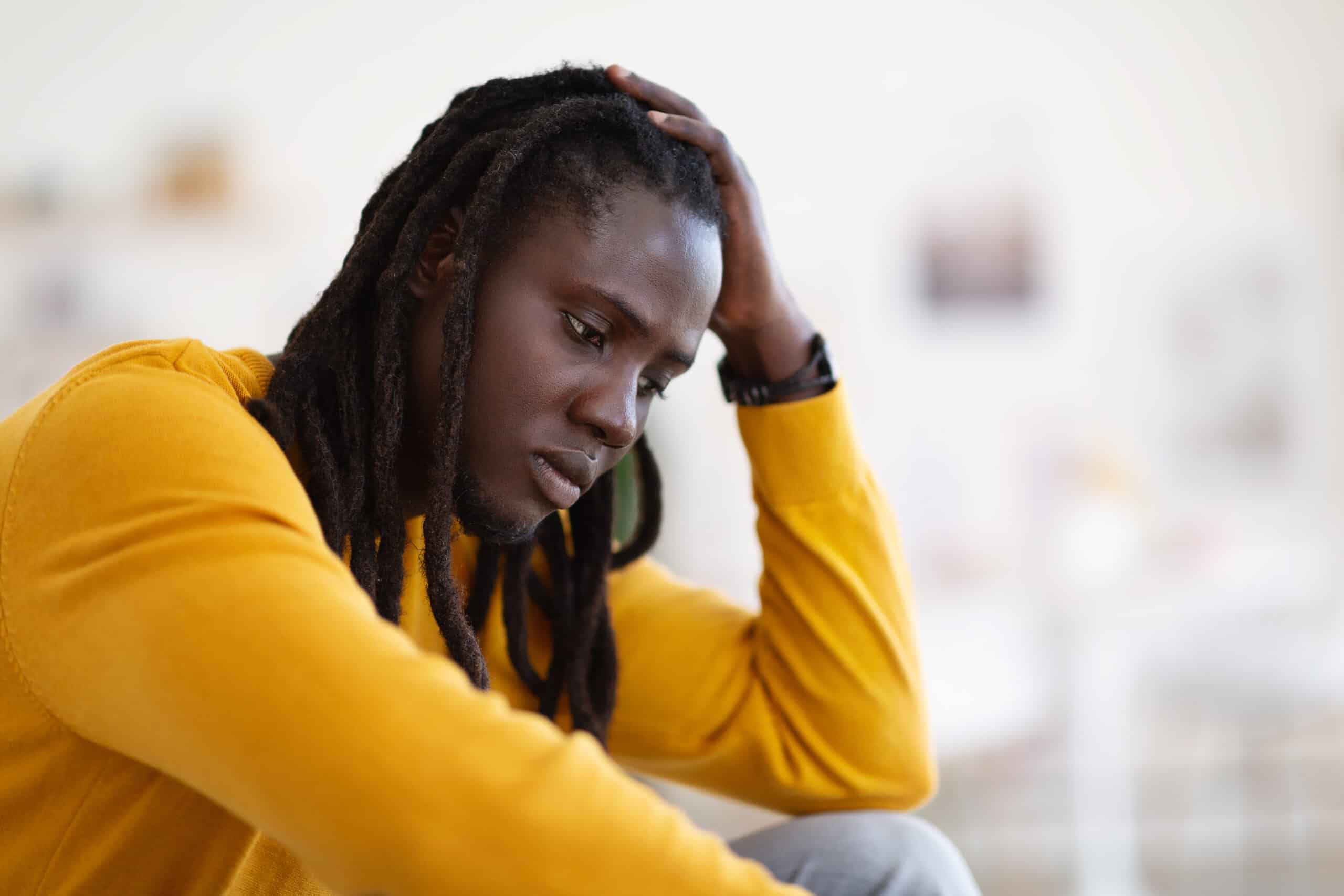 Closeup Portrait Of Depressed African American Guy Sitting At Home, Upset Pensive Black Man Leaning Head On Hand And Looking Away, Suffering Life Problems Or Seasonal Depression, Copy Space