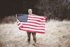 A shallow focus shot of an American soldier holding the American flag
